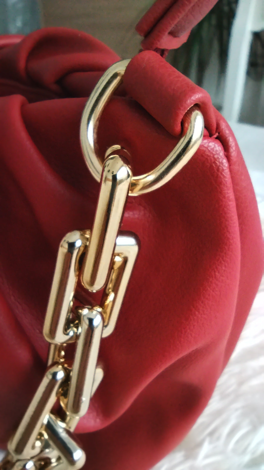 Bolso rojo arrugado con cadena dorada